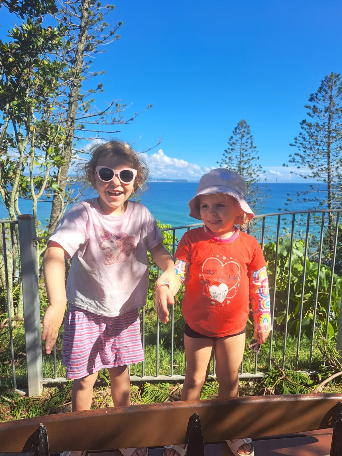 Two kids at the rail overlooking the beach